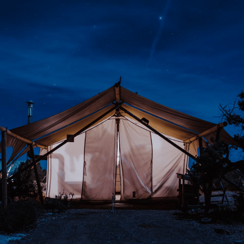 canvas safari wall tent glowing at night