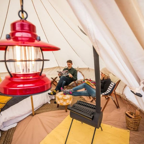 à l'intérieur d'une tente cloche avec des personnes et un poêle