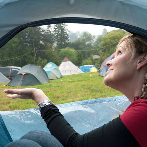 raining outside of tent with person inside camping tent