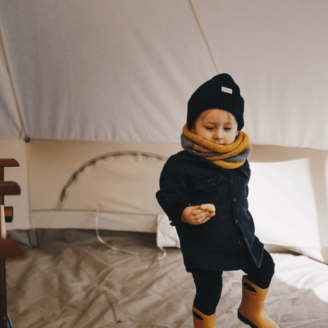 enfant en veste bottes bonnet à l'intérieur de la tente cloche