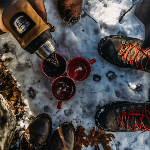 tasses de camp dans la neige avec des bottes