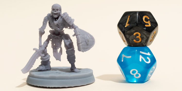 a board game skeleton miniature standing next to two rolling dice