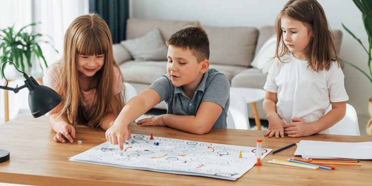 group of three kids, about age 5-7 are playing a board game