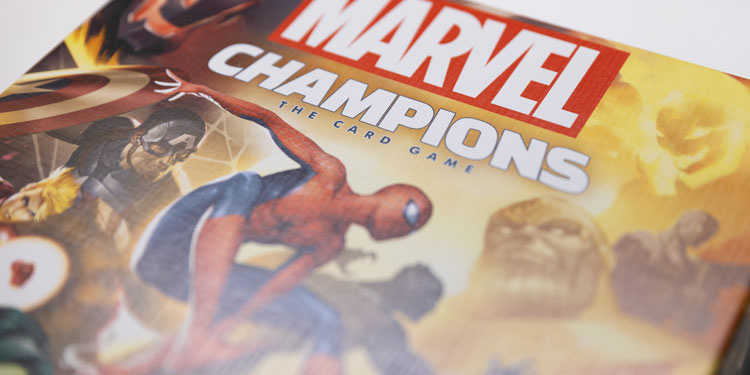 close up of the marvel champions card game's box