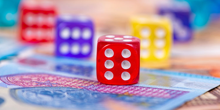 a close up of rolling dice that are placed on top of money bills