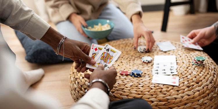 group of friends playing cards, the cards are in the center of frame