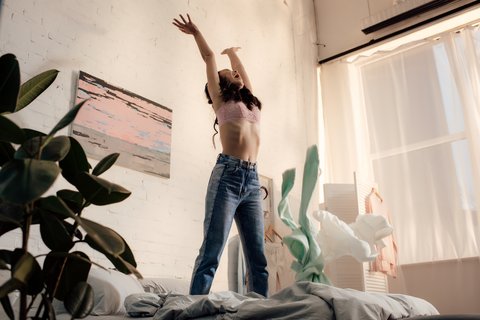 girl standing on bed