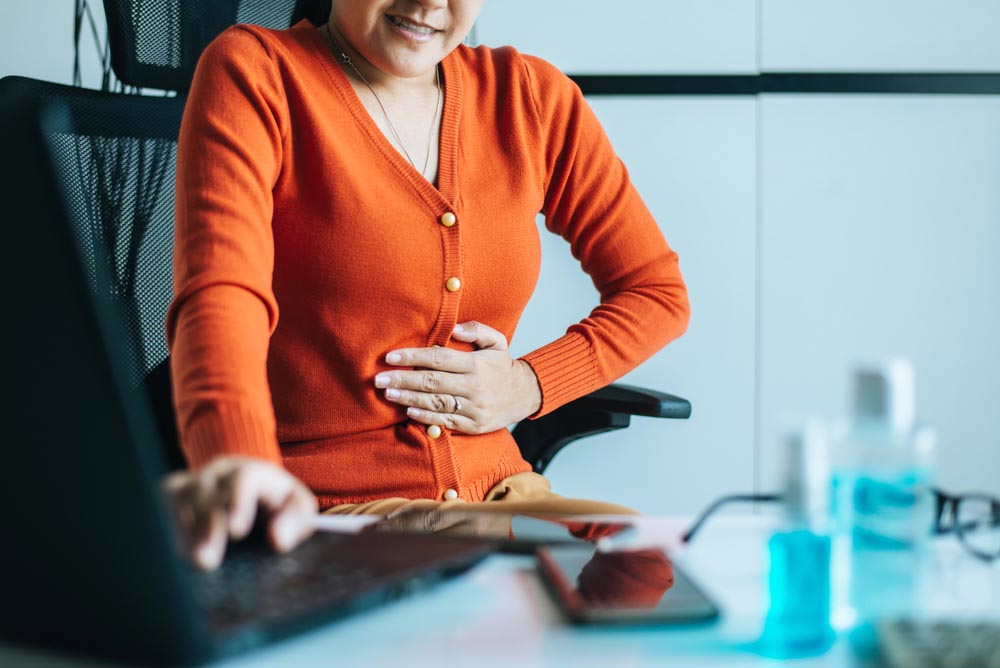 Woman at work suffering from acid reflux