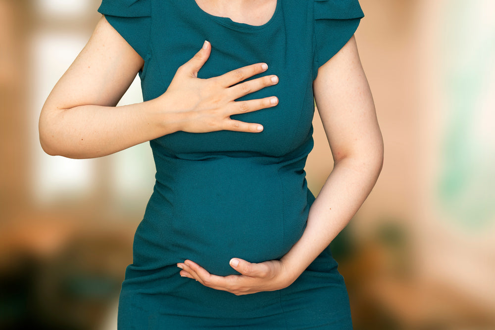 pregnant woman with reflux holding chest