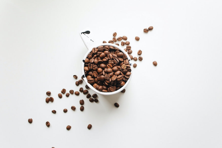 Coffee beans and coffee mug on a white surface