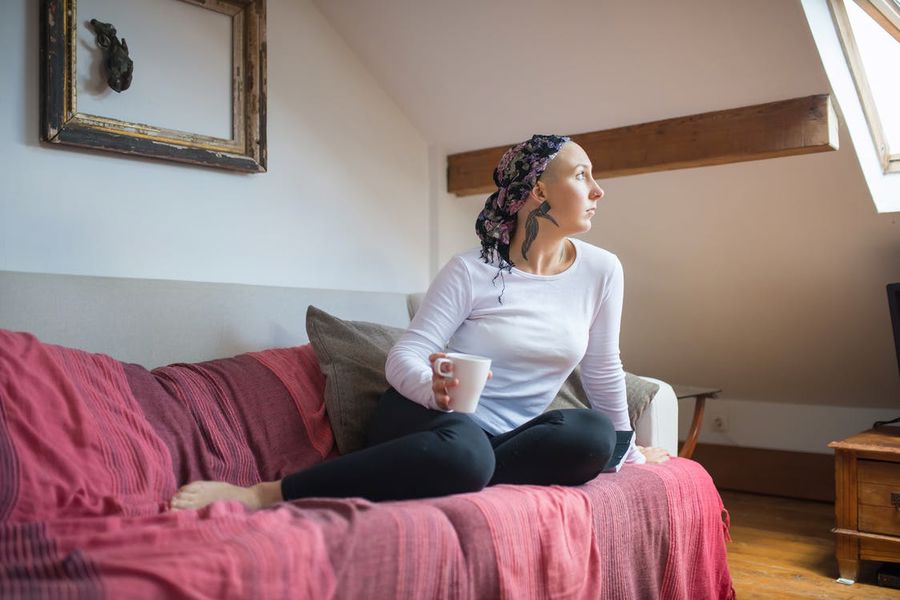 Woman sitting comfortably in a sofa while drinking CBD coffee