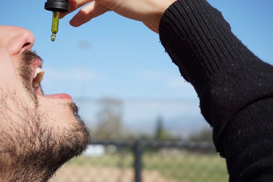 Man taking a CBD oil dropper straight into his mouth