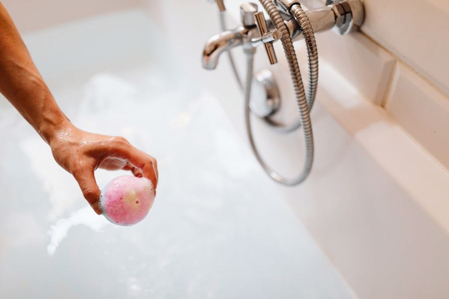 Person adding a bath bomb in a tub