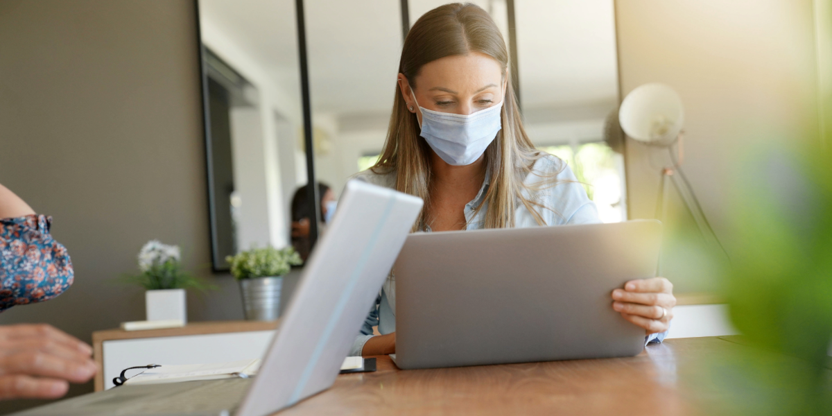 A woman in the office with a face mask on