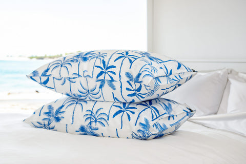 The Palms Silk Pillowcase stacked on bed