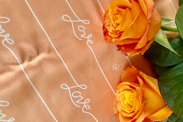 Close up of the Love pillowcase print with peach coloured roses on the right