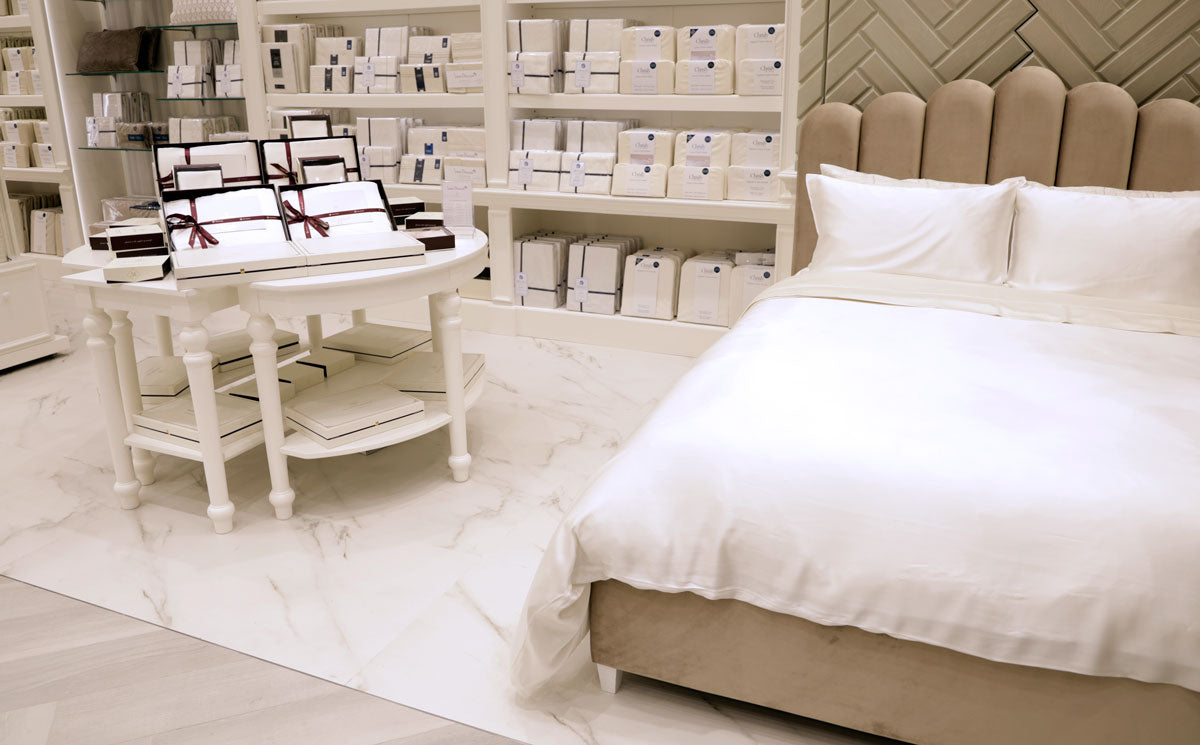 Retail store with dressed bed in mayfairsilk silk sheets and display table with silk bedding gift boxes