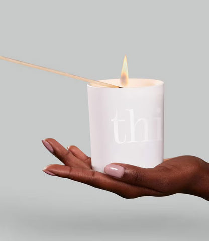 ThisWorks Candle being lit by match and held in a hand