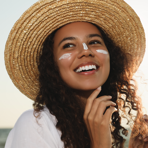 Woman smiling in sun hat with SPF