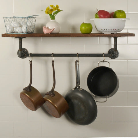 Image of a wooden shelf with industrial pipe hanging racks housing fruits and eggs on top of the shelf with pans and cooking utensil hanging on the pipe bar.