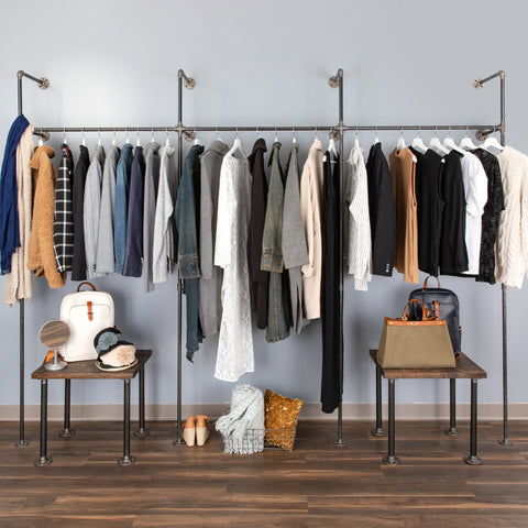 Image of a spacious PIPE DECOR® clothing rack displaying an array of garments, alongside stylish stools and accessories, creating an organized and trendy wardrobe area.