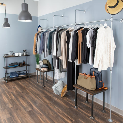 Image of a stylish industrial clothing rack made with pipe decor, displaying a variety of clothes and accessories in a modern room setting, perfect for Mother's Day.