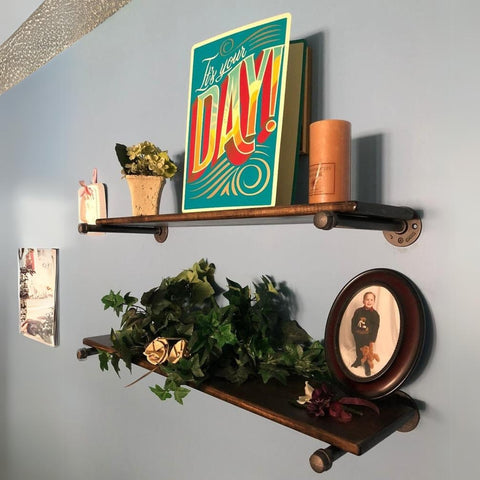 Image of charmingly styled pipe shelves displaying a vibrant "It's Your Day!" card, family photos, and decorative plants, adding a personal touch to the home.