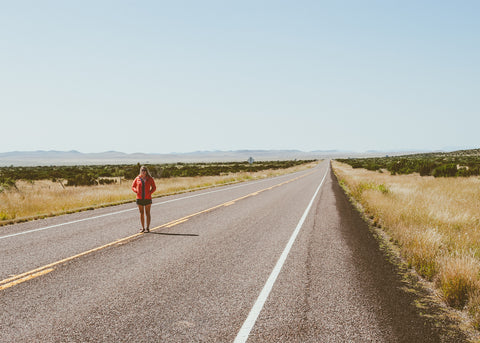 woman standing in the road in the mountains of Far West Texas south of Fort Stockton.