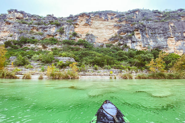 kayak on the devils river with limestone cliffs in the background