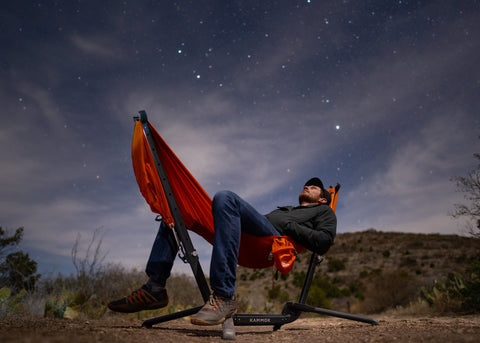 Man sitting in Swiftlet gazing up at the night sky and stars overhead.