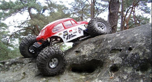 Crawler télécommandé avec ses pneus et suspensions sur un obstacle