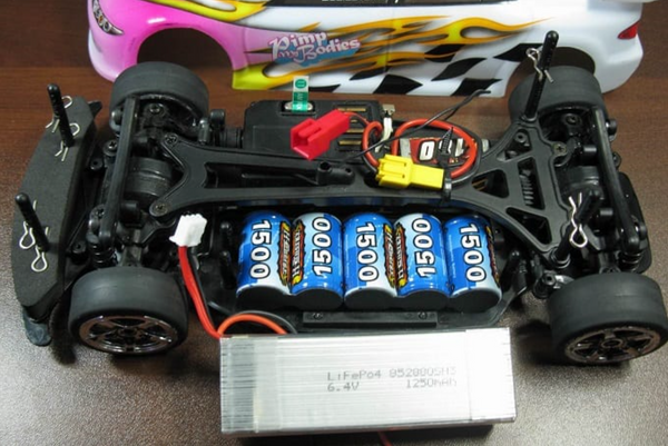 Une voiture télécommandée dénudée avec ses circuits, batteries et composants visibles - VéhTél