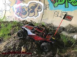 Voiture de course cabrant sur une petite montagne de boue