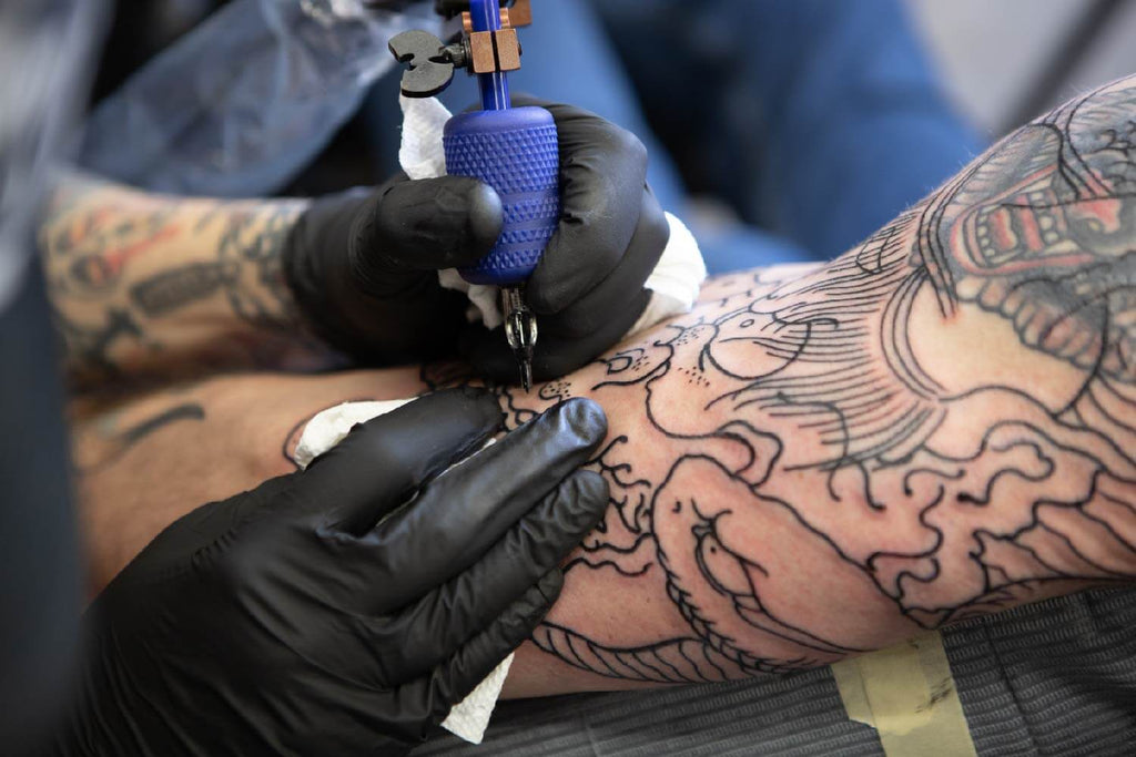 artist tattooing forearm