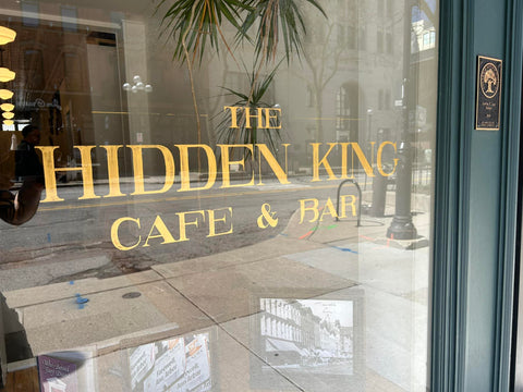 The Hidden King Cafe & Bar window with gold lettering