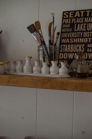 Paint brushes sitting on pottery studio shelf