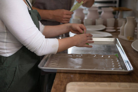 Handmade ceramics sitting on a tray prior to being put in the kiln