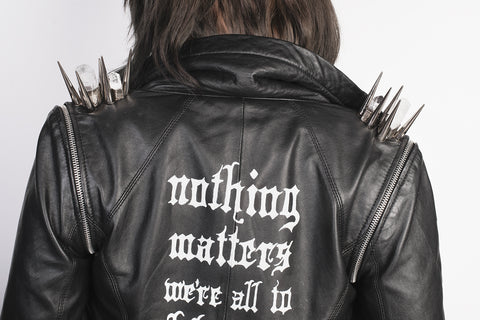 leather jacket with crystal and metal spikes. hand painted design on back reads "nothing matters, were all to blame"