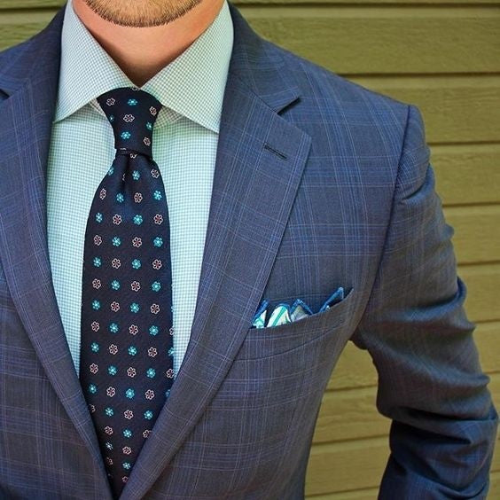 With white shirt, navy blue tie, cobalt blue jacket and brown