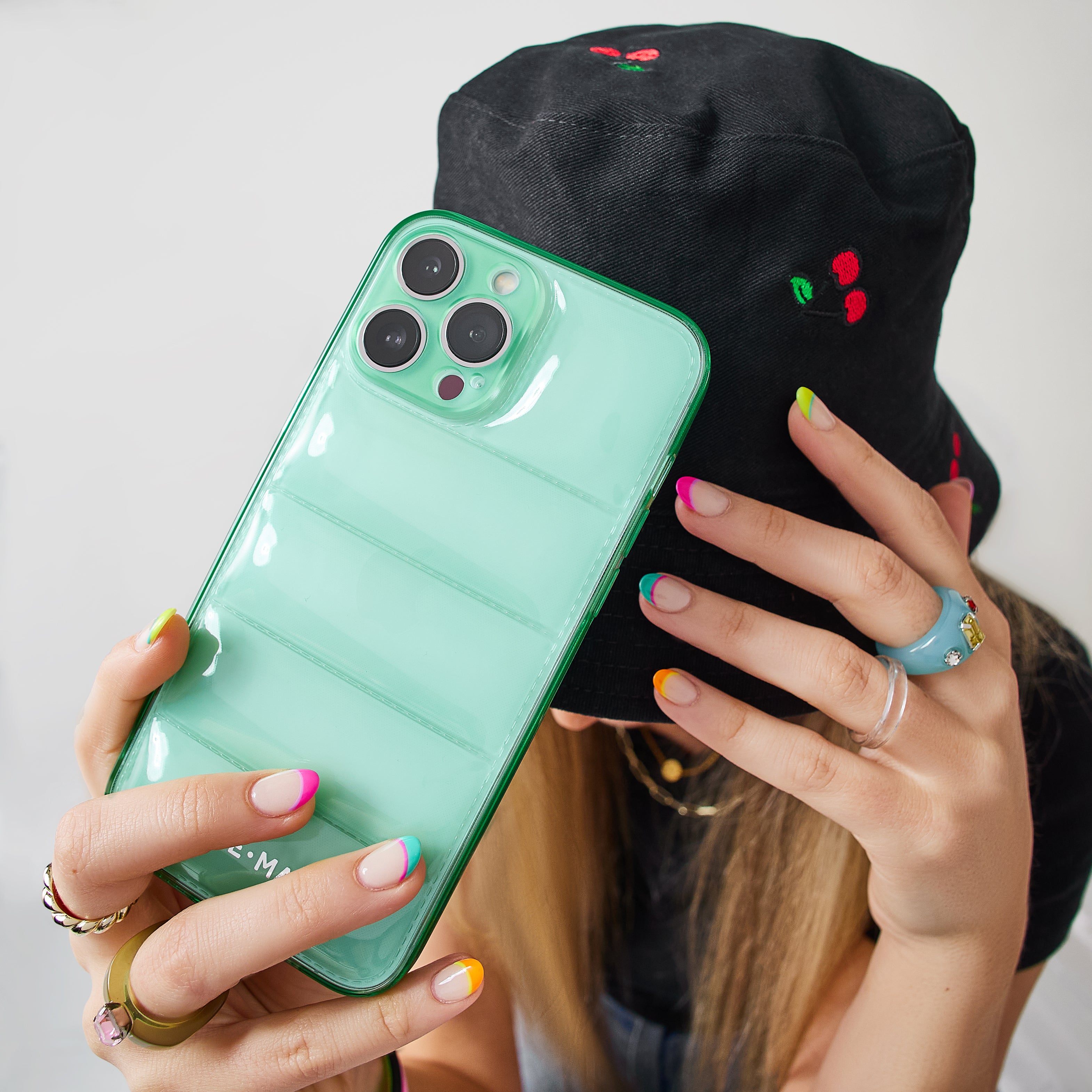Girl holding green Jelly puff above her bucket hat.