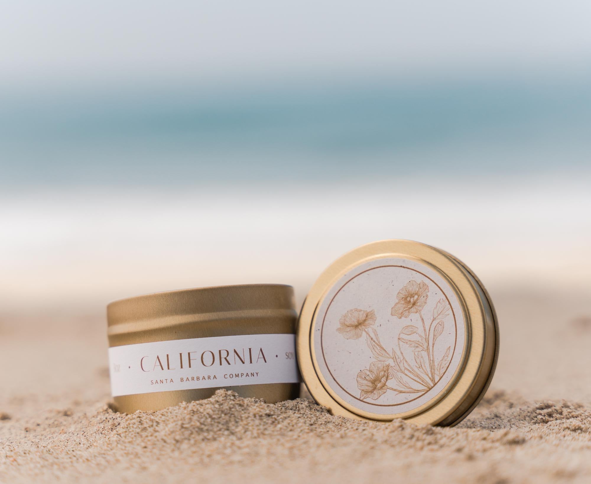 Small gold candle tin sitting on the beach.