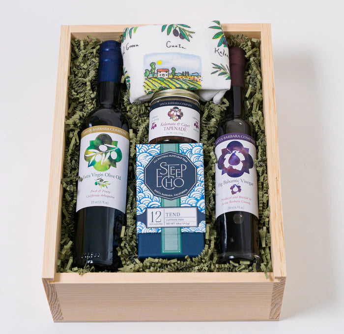 Extra virgin olive oil, olive inspired gifts and fig balsamic vinegar tucked in a wood box