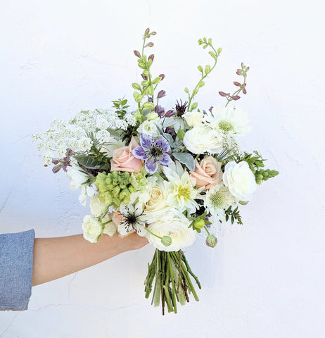Hand holding Mother's Day graceful and sustainable flower arrangement