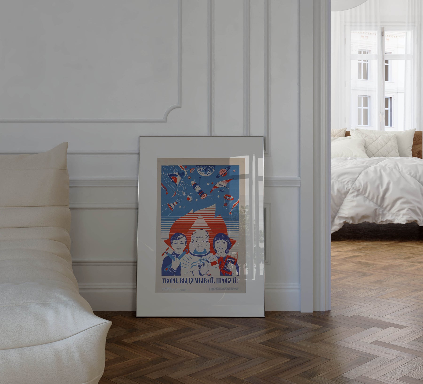 Create, Invent, Try! – Soviet propaganda poster from 1982 by Tatyana Ivanovna Dmitrieva featuring children, a blue book, and red aircraft models, framed in a French apartment with parquet floors, white walls and soft sunlight