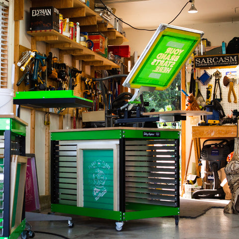 a riley 150 press on a cart in a garage. a flash dryer is next to it