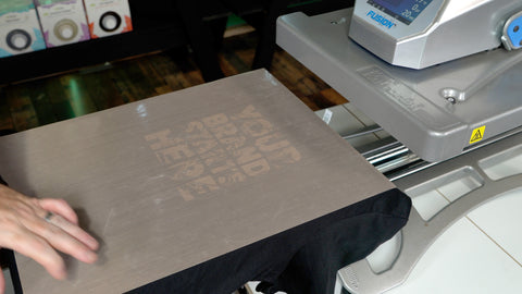 a teflon sheet on a shirt that's on the platen of a heat press