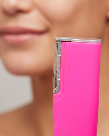Model holding LUXE+ device in Pop Pink with Edge filled with peach fuzz