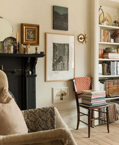 Traditional room with a fireplace, framed art, and red checkered blanket over a chair