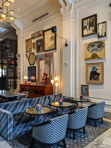 Design maximaliste avec des chaises à carreaux et un mur d'art encadré