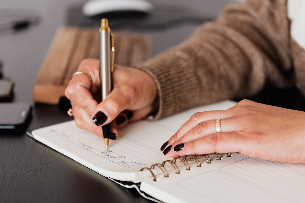 Person writing on notebook